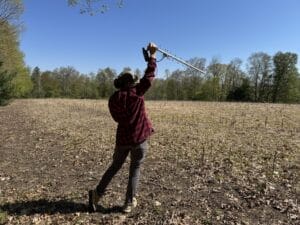 Field researcher holds up antenna to track turkey with GPS backpack.